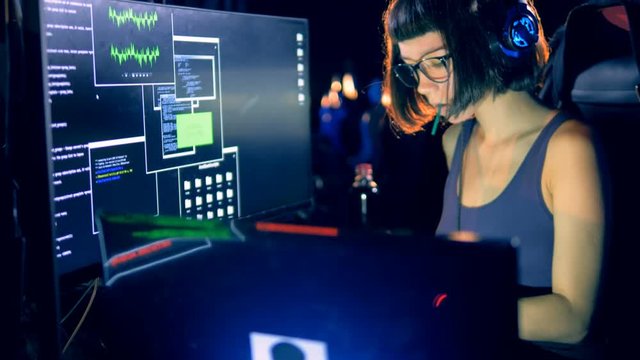 Young female hacker is operating a computer