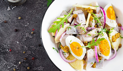 Traditional  salad of salted herring fillet, fresh apples,  red onion  and eggs. Kosher food. Scandinavian cuisine. Top view. Flat lay