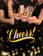 Cheers hand lettering! Group of people cheering with champagne flutes with holiday lights on background.