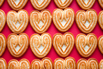 Cookies for Heart Day or Valentine Day in heart shape on red background. Top view pattern.