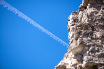 Ancient fortress stone wall and plane flying in background. Contrast between nowadays and medieval...