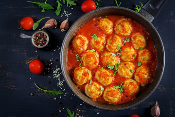Chicken meatballs with tomato sauce in a pan. Dinner. Top view. Dark background.