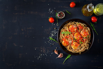 Italian pasta. Spaghetti with meatballs and parmesan cheese in black plate on dark rustic wood background.  Dinner. Top view. Slow food concept