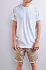 Obraz premium Stylish slim guy in a blank T-shirt on a white studio background.
