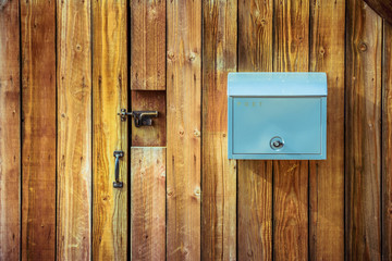 Blue mail box hanging on wooden wall