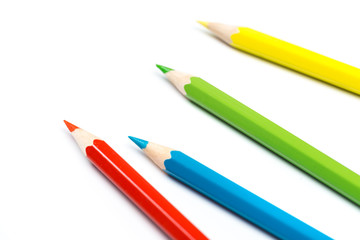 Colour pencils on white background, top view.