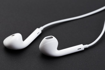 white earphones on black background.