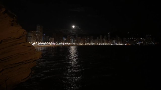 Full moon city scape over looking a beach in Spain