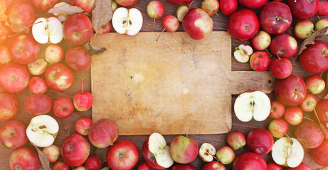 Naklejka na ściany i meble Thanksgiving background with apples, acorns, berries and fall leaves on the old wooden background. Autumn background with copy space. Abundant harvest concept.