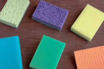 multicolored sponges for washing dishes on a wooden background