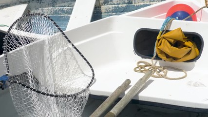 Interior of a small fishing boat, containing fishing net and protective waterproof oilskins.