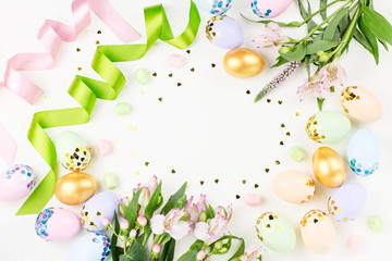 Naklejka na ściany i meble Festive Easter background with decorated eggs, flowers, candy and ribbons in pastel colors on white. Copy space