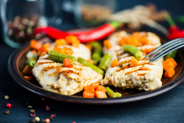 grilled turkey fillet with vegetables, pepper and spices on a plate