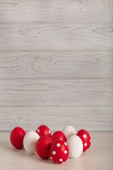 Obraz premium Happy Easter! Painted Easter eggs - red, white and red with white polka dots on a gray wooden background.