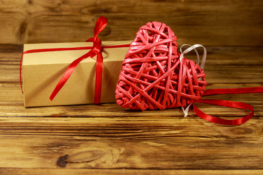 Gift box and red heart on wooden background. Valentine's day concept