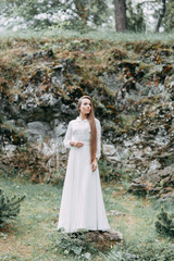 Morning bride on a beautiful panoramic location. Girl in boudoir dress and cliffs.