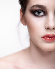 Closeup macro portrait of female face.  Girl with perfect skin, green pistachio colour eyes and violet - black smoky eyes make-up.