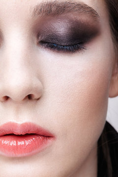 Closeup macro portrait of female face.  Girl with perfect skin and violet - black smoky eyes make-up.