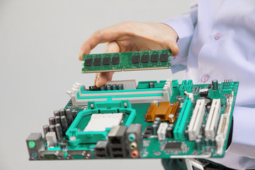 RAM and motherboard in men's hands close-up isolated on light background