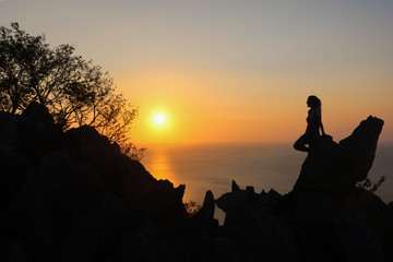 Fototapeta premium Happy woman enjoying on the top of the mountain at sunset.