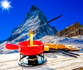 Fondue cheese, swiss winter ski holidays break for lunch, mountain view Matterhorn in Zermatt,...