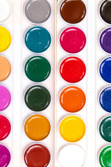 palette with paints close-up lie isolated on yellow background