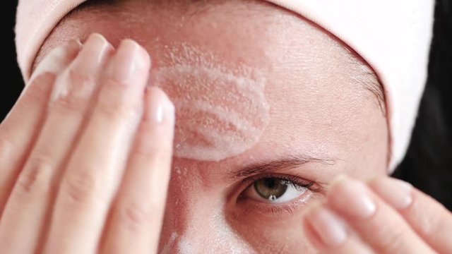 Woman with problem skin and enlarged pores close-up. The girl applies a means for cleansing the skin, massaging and cleansing it from contamination. The concept of skin care prone to acne. Natural
