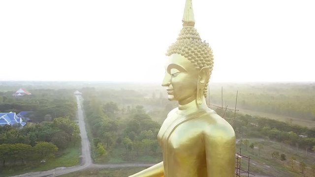 Aerial view of Big Golden buddha statue at sun rise, countryside of Thailand