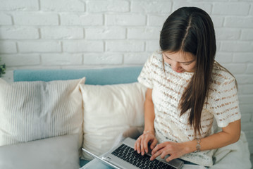 Beautiful girl is typing on a laptop.