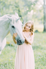 Aerial photo shoot at sunset in the forest with a horse. A girl in a flying dress with a unicorn.