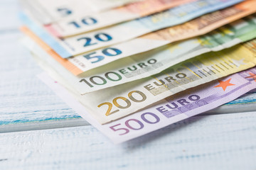 Close-up a pile of banknotes lying on a wooden table