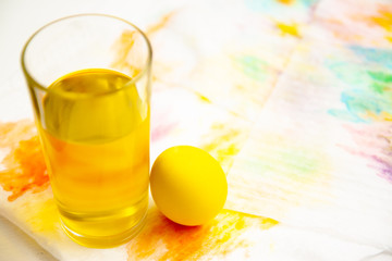 Prepearing for Easter. Coloring painting eggs in glasses with Yellow color. copyspace