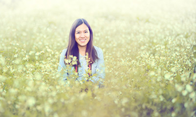 beautiful asian young woman sitting in white  flowers field