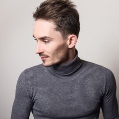 Obraz premium Handsome young elegant man in grey golf.