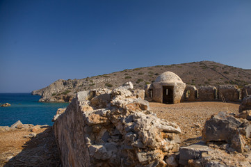 Fragment of a defense tower and walls in the Spinalonga fortress. Sea view from the leper island in Greece.