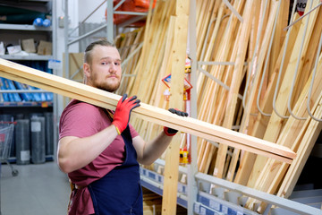 worker or seller in construction store or warehouse wood section at work