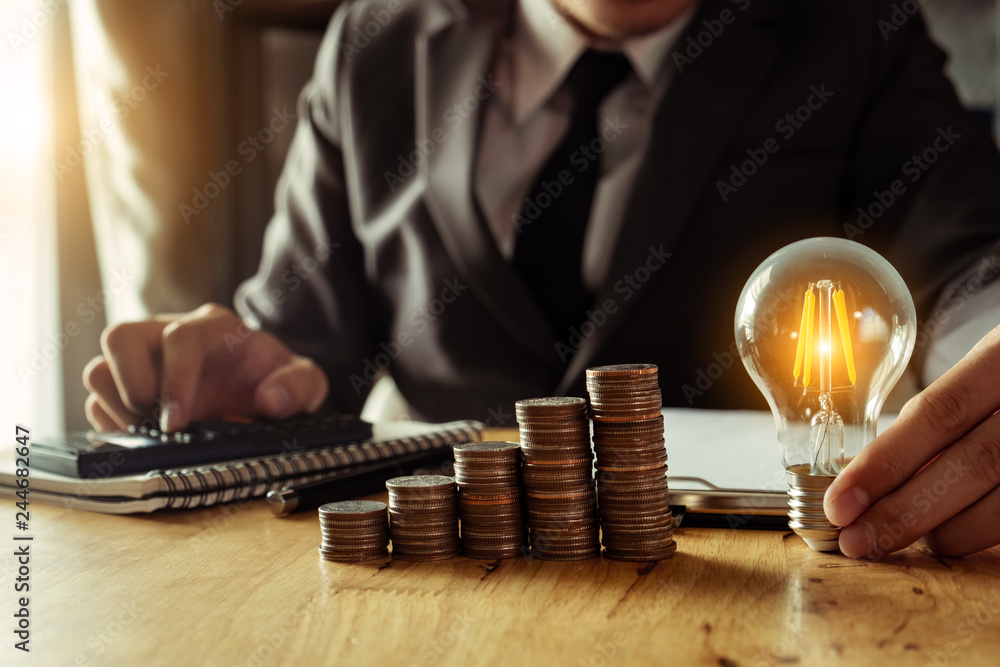 Poster business man hand holding lightbulb with using smartphone and calculator to calculate and money stac