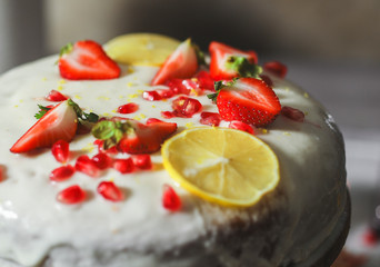 Lemon cake with fresh strawberries and pomegranate seeds
