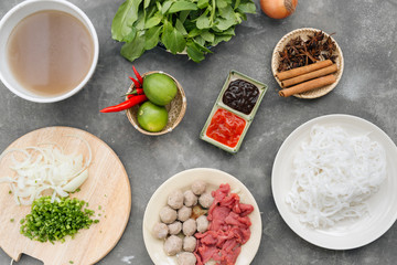 Traditional vietnamese noodle soups pho in bowls, concrete background. Vietnamese beef soup pho bo,...