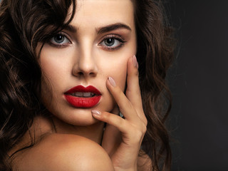 Fototapeta premium Face of a beautiful woman with a smoky eye makeup and red lipstick