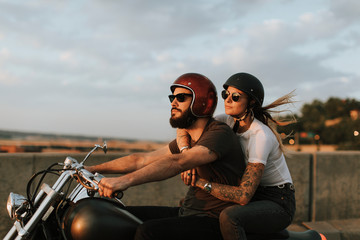 Fototapeta na wymiar Biker couple riding down the road in the sunset