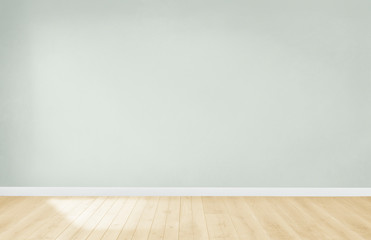 Lichtgroene muur in een lege ruimte met een houten vloer