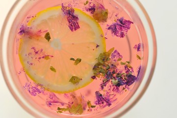 マロウのハーブがお湯に浮かんでレモンでピンク色になった状態です