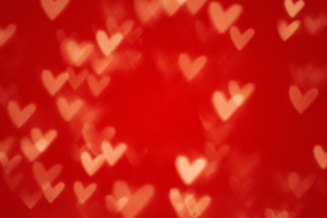 Valentine heart bokeh lights against a red background