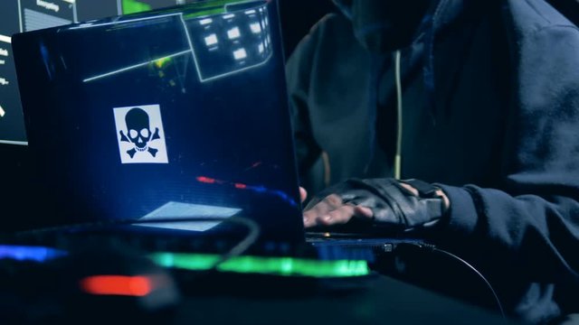 Hacker's hands are typing on a customized laptop