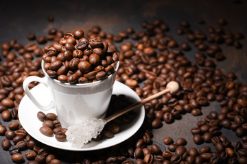 Coffee beans in coffee cup on black background