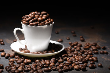 Coffee beans in coffee cup on black background