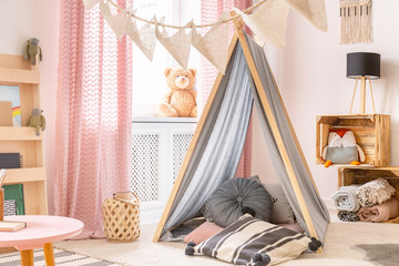 Real photo of a tent and pillows in a kid's room interior © Photographee.eu