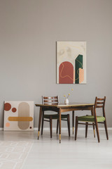 Abstract paintings on grey wall of retro dining room interior