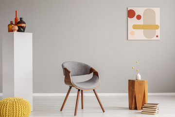 Trendy grey and wooden chair in retro living room interior
